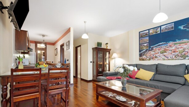 Un salon comprenant un canapé, une table basse et un coin repas avec des chaises et une table.