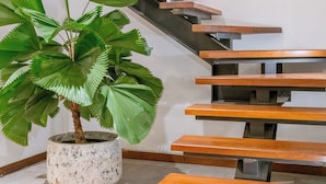 A staircase with wooden steps and a potted plant. - Flores Villa by Betterplace (Canggu)