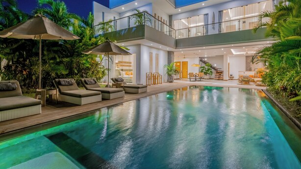 A modern two-story house with a swimming pool, outdoor seating, and a balcony. - Flores Villa by Betterplace (Canggu)