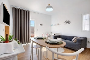 A modern living room with a dining table, sofa, and a mounted bicycle.