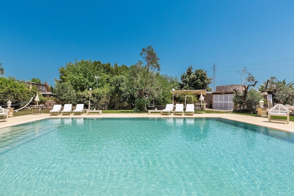 A clear swimming pool with white lounge chairs and a pergola. - 3373 Masseria Cucuruzza - Camera Maria (Ugento)