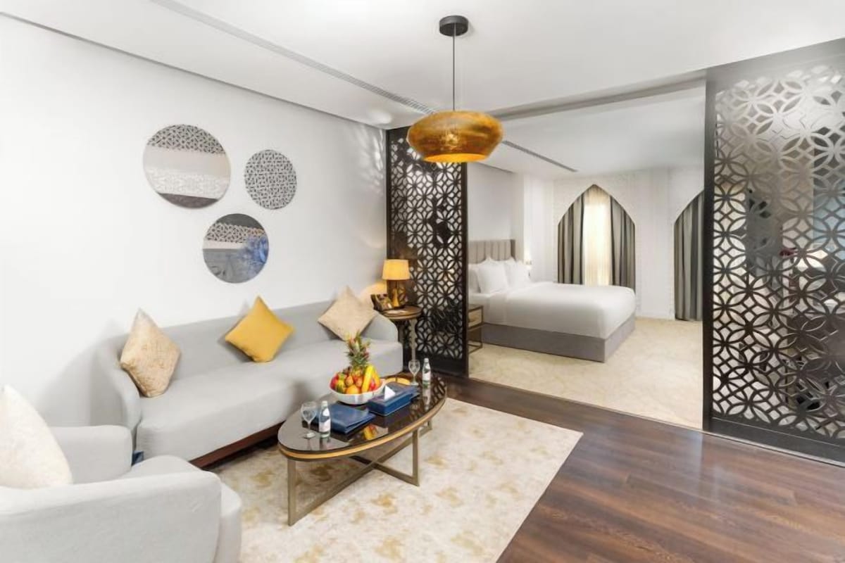 Uma sala de estar moderna com sofá, mesa de centro, obra de arte decorativa e um painel decorativo.