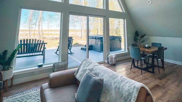 Un espacioso dormitorio tipo loft con amplias ventanas, una zona de estar acogedora y vistas al exterior.