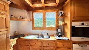 A wooden kitchen with a sink, coffee maker, and Bosch appliances.