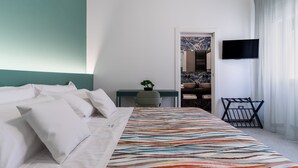 A hotel room with a bed, a desk, a chair, a TV, and a window with curtains. - 3429 Residence Medusa - Suite Zeus PT (Porto Cesareo)