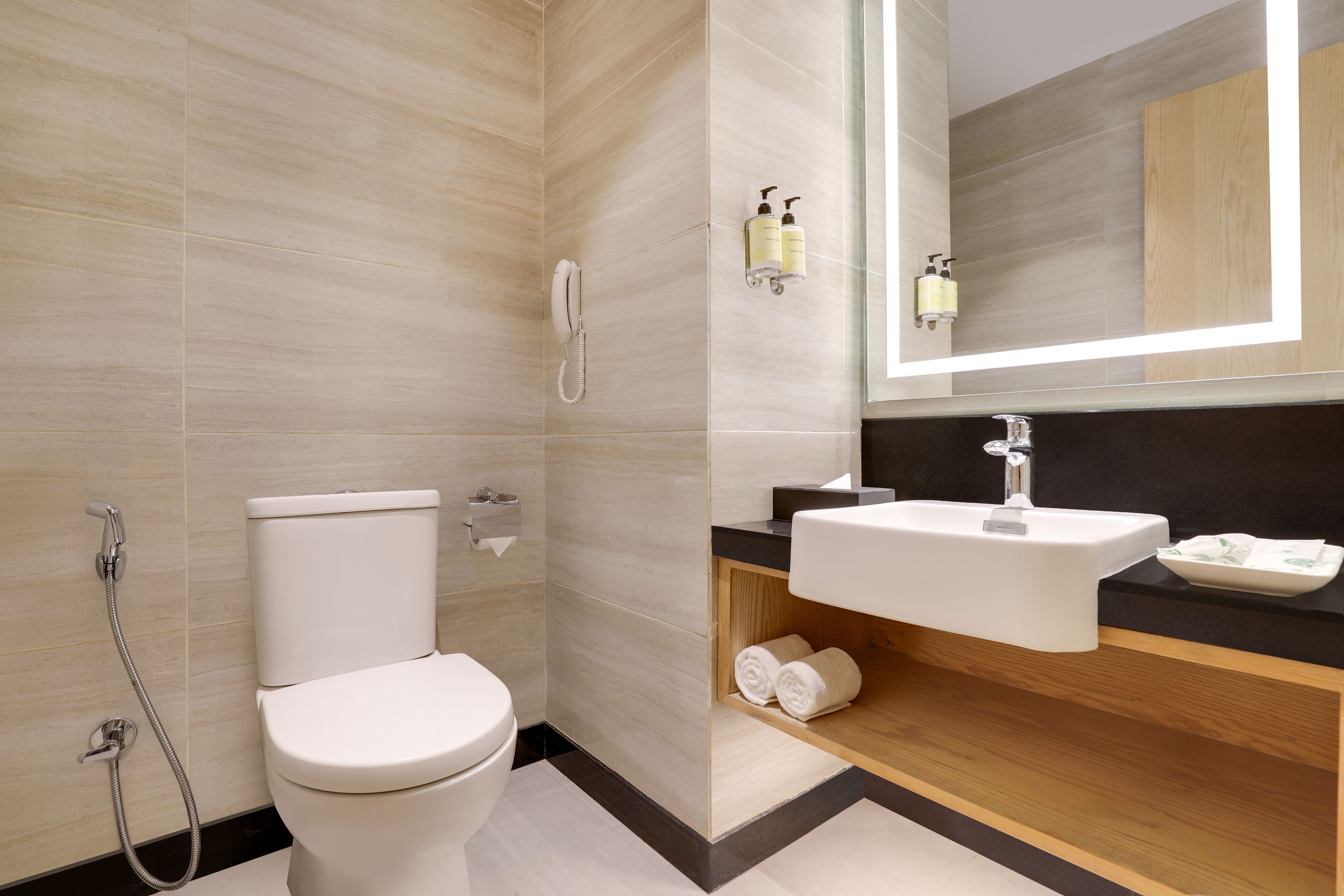 Un baño moderno con inodoro, ducha, lavabo y espejo.
