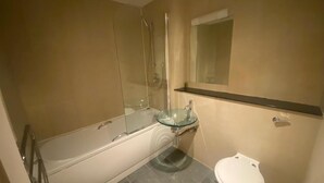 A bathroom with a glass-enclosed shower, a glass sink, and a toilet. - Immaculate 1-bed Apartment in Birmingham (Birmingham)