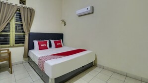 Een hotelkamer met een bed, gordijnen, een airconditioner, een raam en een stoel.