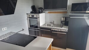 Eine moderne Küche mit Einbauherd, Backofen und Mikrowelle.