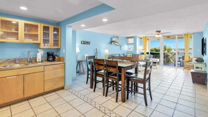A spacious kitchen with wooden cabinets and a dining area with a table and chairs. - Waterfront Condo Dock Pool Near Duval St (Key West)