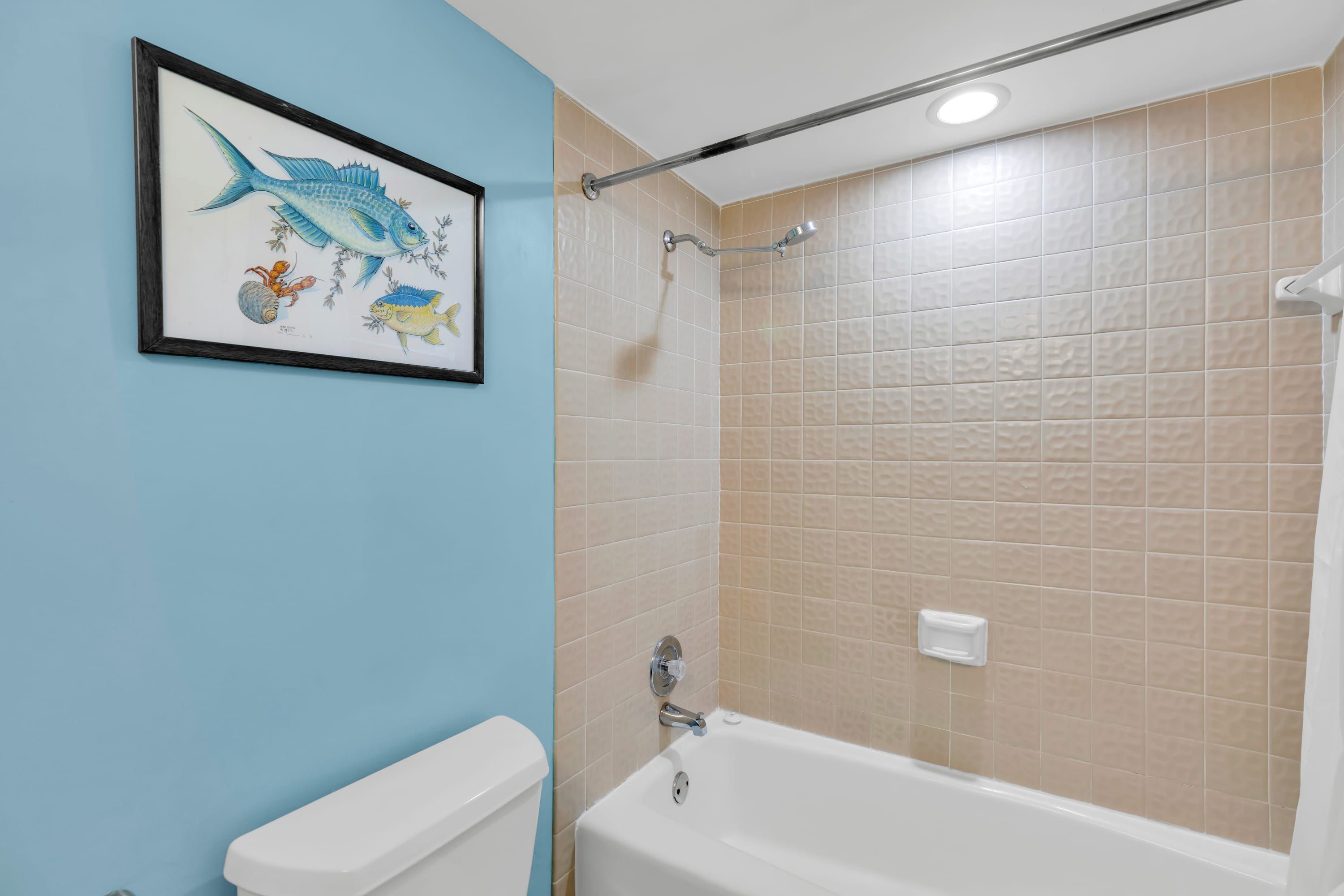 A bathroom with a bathtub, a toilet, and a shower with a glass door.