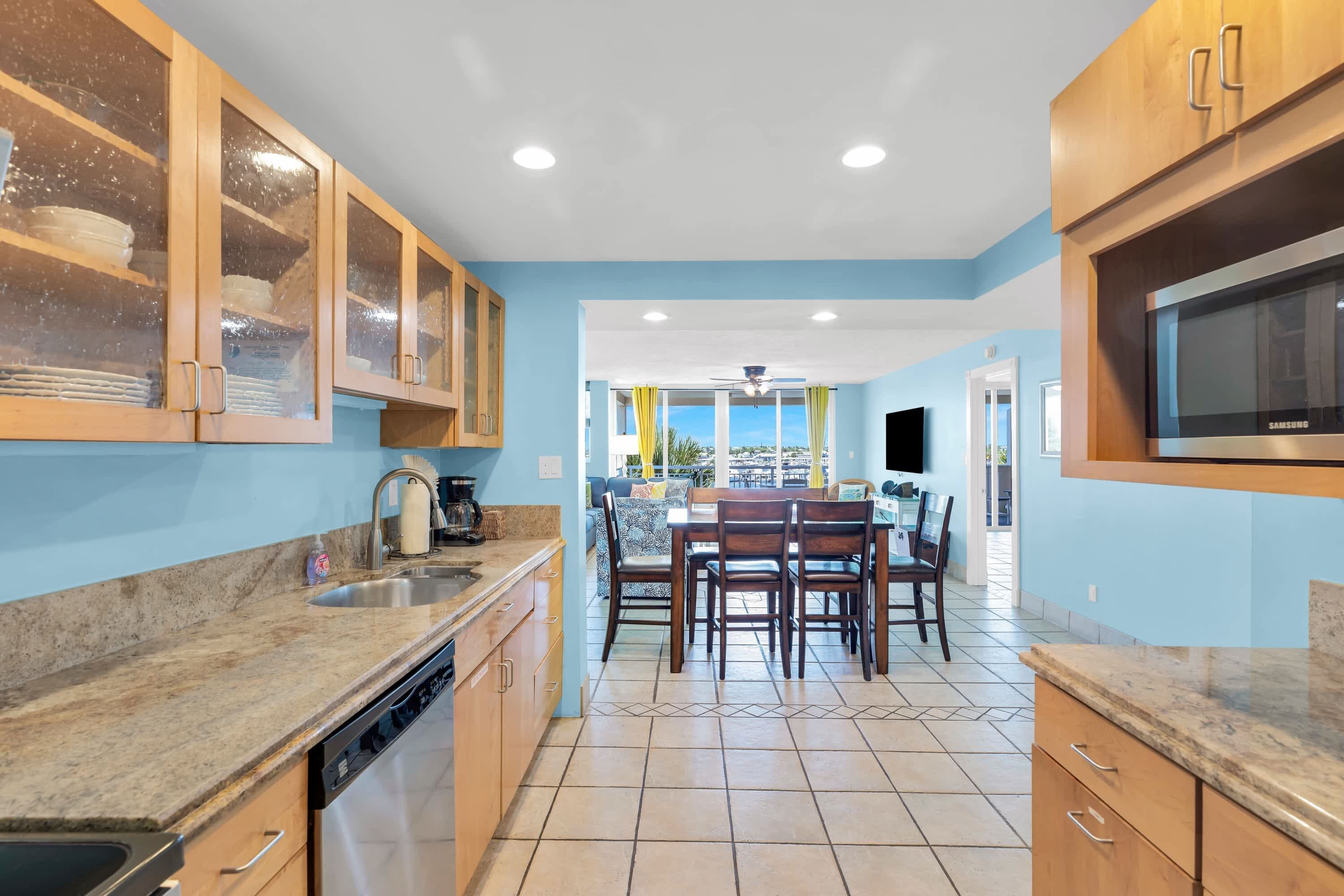 Una cocina moderna con armarios de madera, lavavajillas integrado y un amplio ventanal con vistas al exterior.
