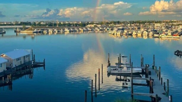 A marina with boats docked, a clear sky, and a rainbow. - Waterfront Condo Dock Pool Near Duval St (Key West)