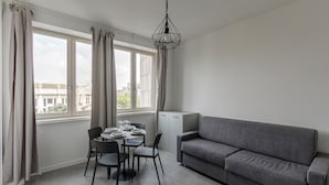 A modern living room with a grey sofa, a dining table with chairs, and a geometric pendant light. - IM HOME-NAPO TORRIANI STAZIONE CENTRALE (Milan)