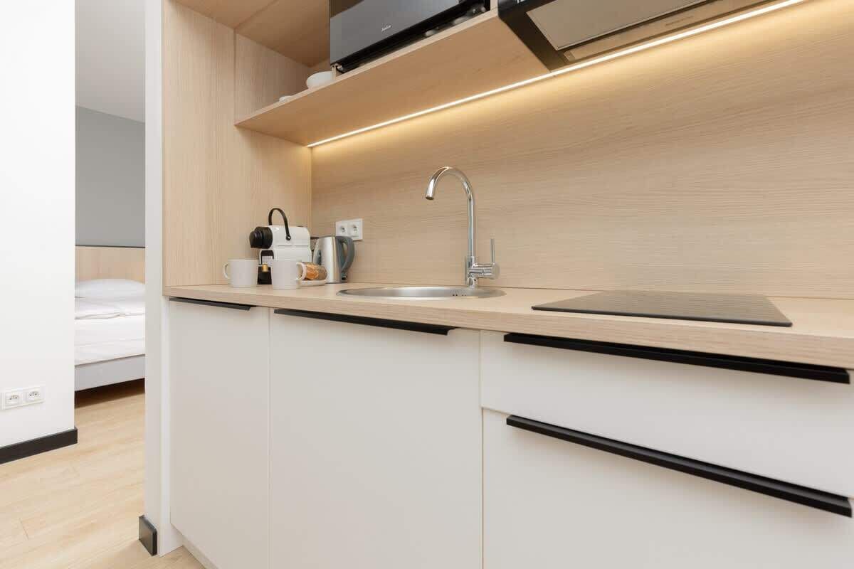 Una cocina moderna con un lavamanos integrado, una cafetera y un hervidor.