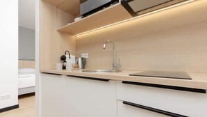 A modern kitchen with a built-in sink, a coffee maker, and a kettle. - Comfortable Studio in Praga | Parking and Air Conditioning (Warszawa)