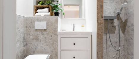 Un baño moderno con inodoro, lavabo y ducha.