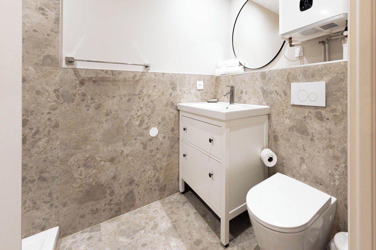 Un baño con un lavabo blanco, un inodoro y un perchero para toallas.