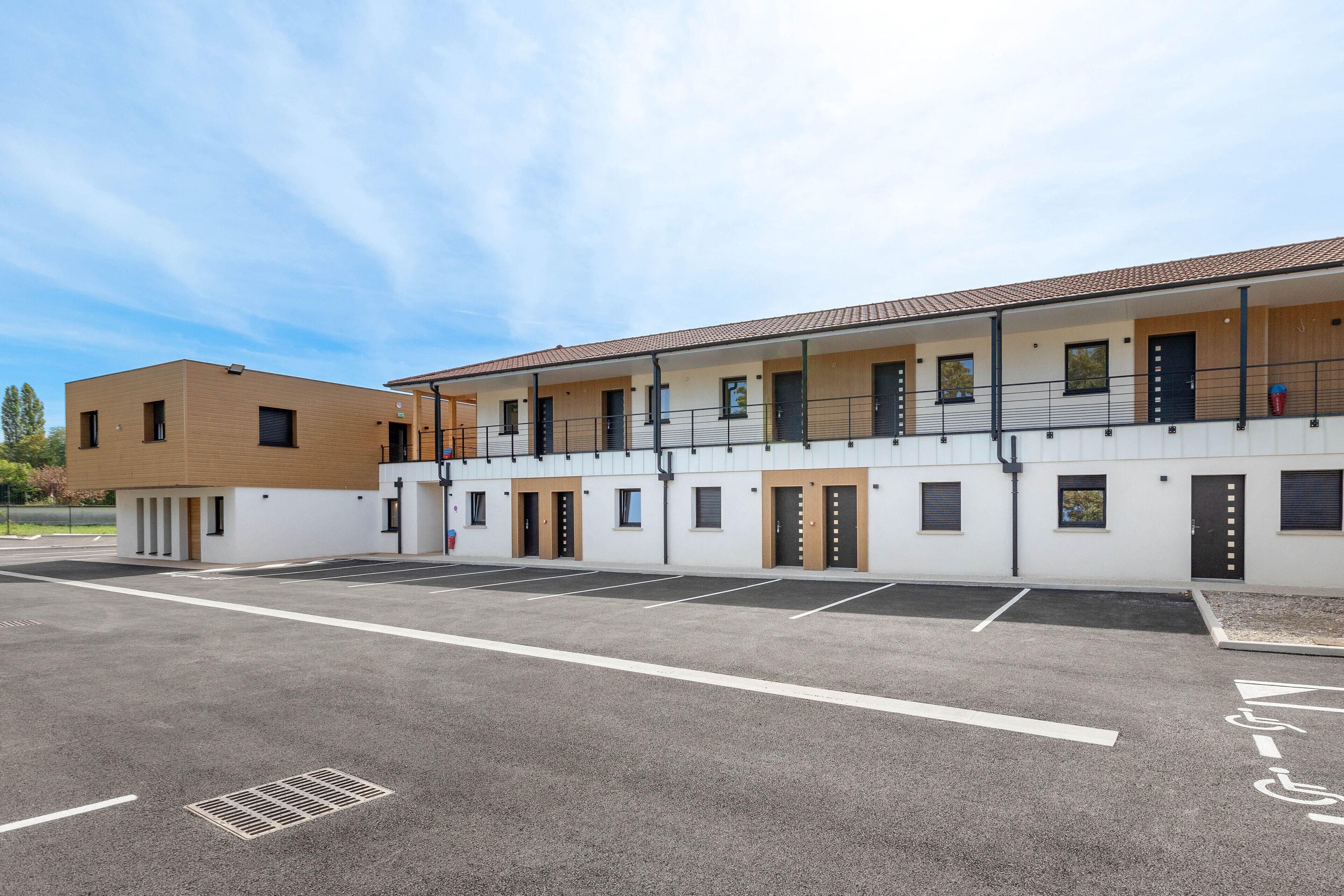 A modern building with a parking lot and multiple rooms.