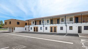 A modern building with a parking lot and multiple rooms.