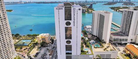 A high-rise hotel with a central atrium, surrounded by a marina and water views.