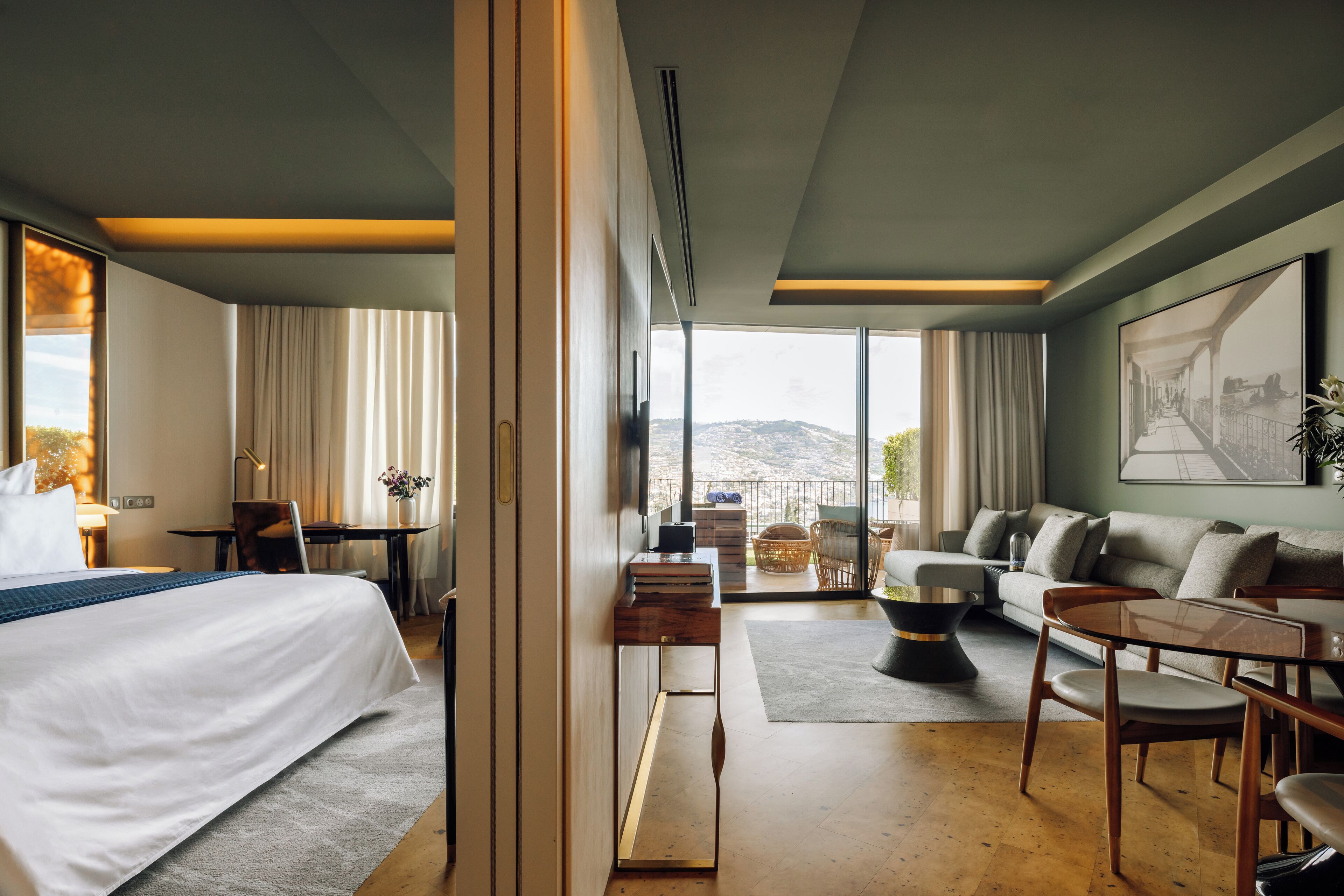 Hotelkamer met een groot bed, een sofa, een eethoek en uitzicht op de omgeving.
