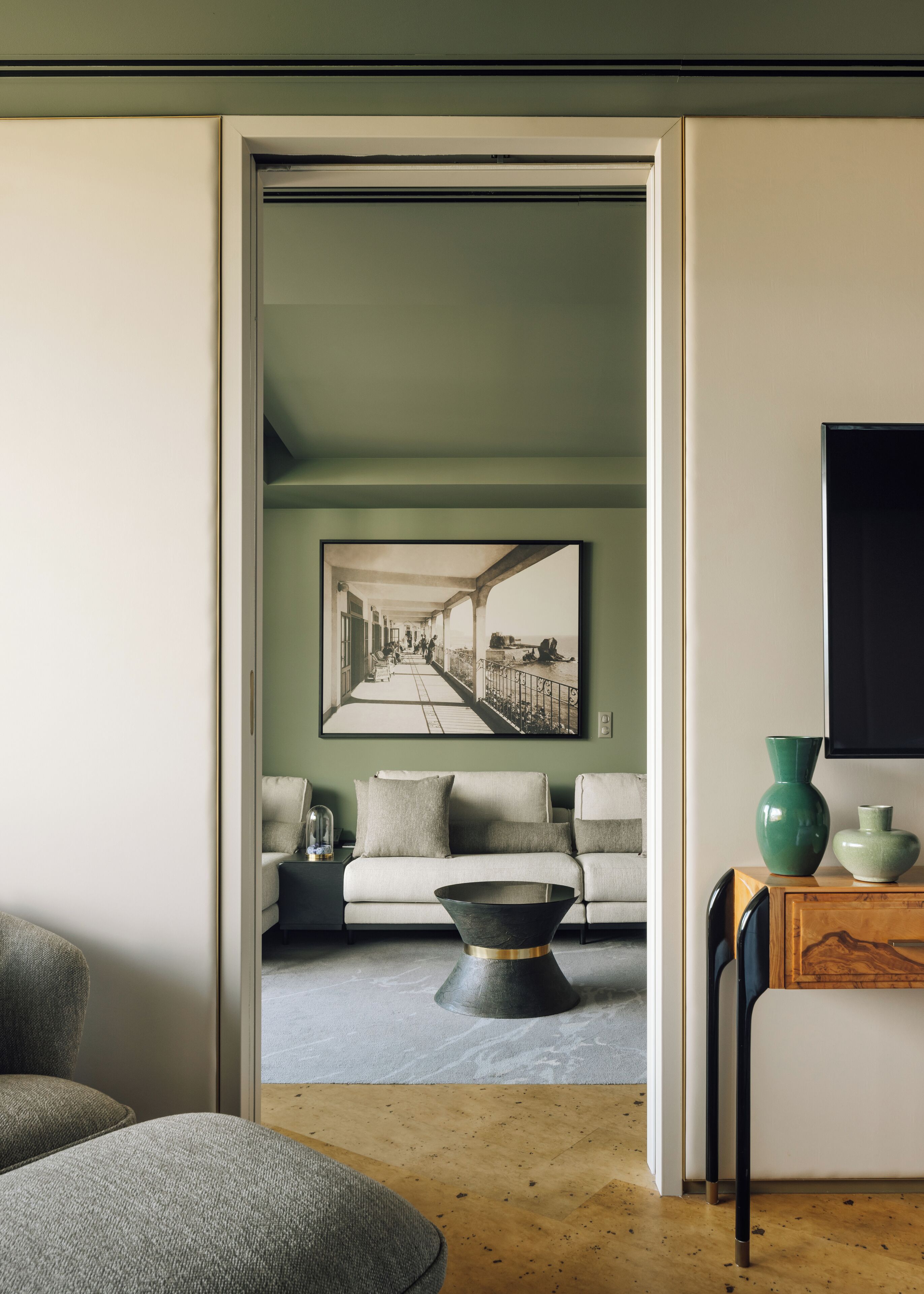 Una sala de estar moderna con un sofá, una mesa de centro y un cuadro de una escena callejera.