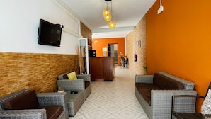 A lobby with wicker sofas, a reception desk, and a patterned floor.