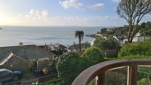 Een kustgezicht met huizen, een palmboom en een heldere lucht.