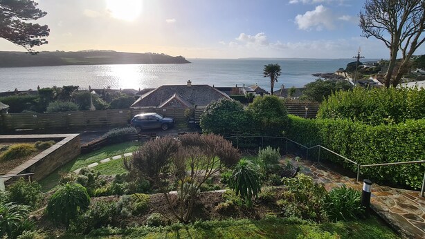 Une vue sur la côte, avec une maison, un jardin et une voiture garée dans l’allée.