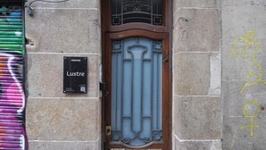 A door with a sign that reads "Lustre" and a QR code. - Numa | Lustre Apartments (Barcelona)