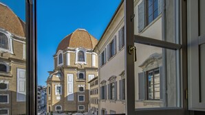 A view through an open window of a building with a prominent dome and a tiled roof, adjacent to a street with other buildings. - Apartment in Florence with 3 bedrooms sleeps 5 (Florence)