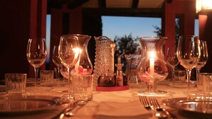 A table set for dining with multiple wine glasses, a candle, and a pitcher.