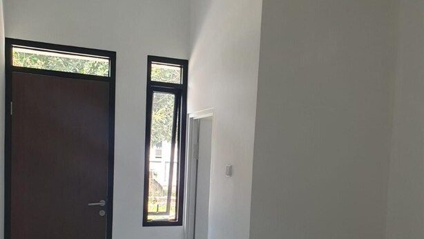 A room with a tiled floor, a door, a window, and a bed.