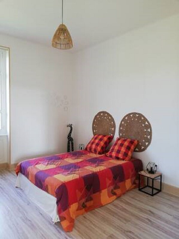 Una camera da letto con un letto, un comodino, una lampada e un lampadario.