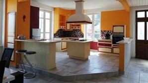 Une cuisine dotée d’un îlot central, de tabourets de bar et d’une grande fenêtre.