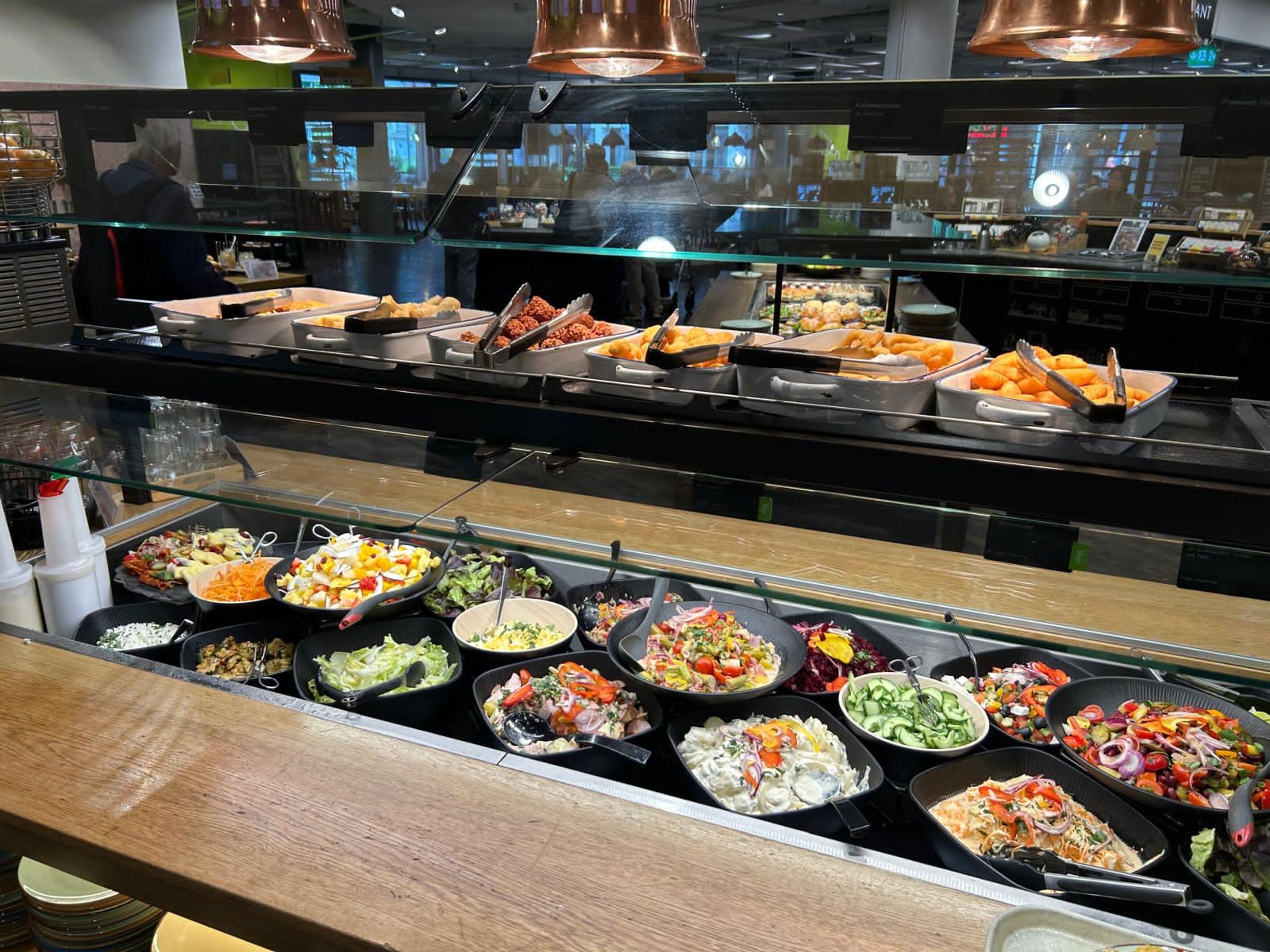 Een buffet met diverse gerechten, waaronder salades, pasta en meer.