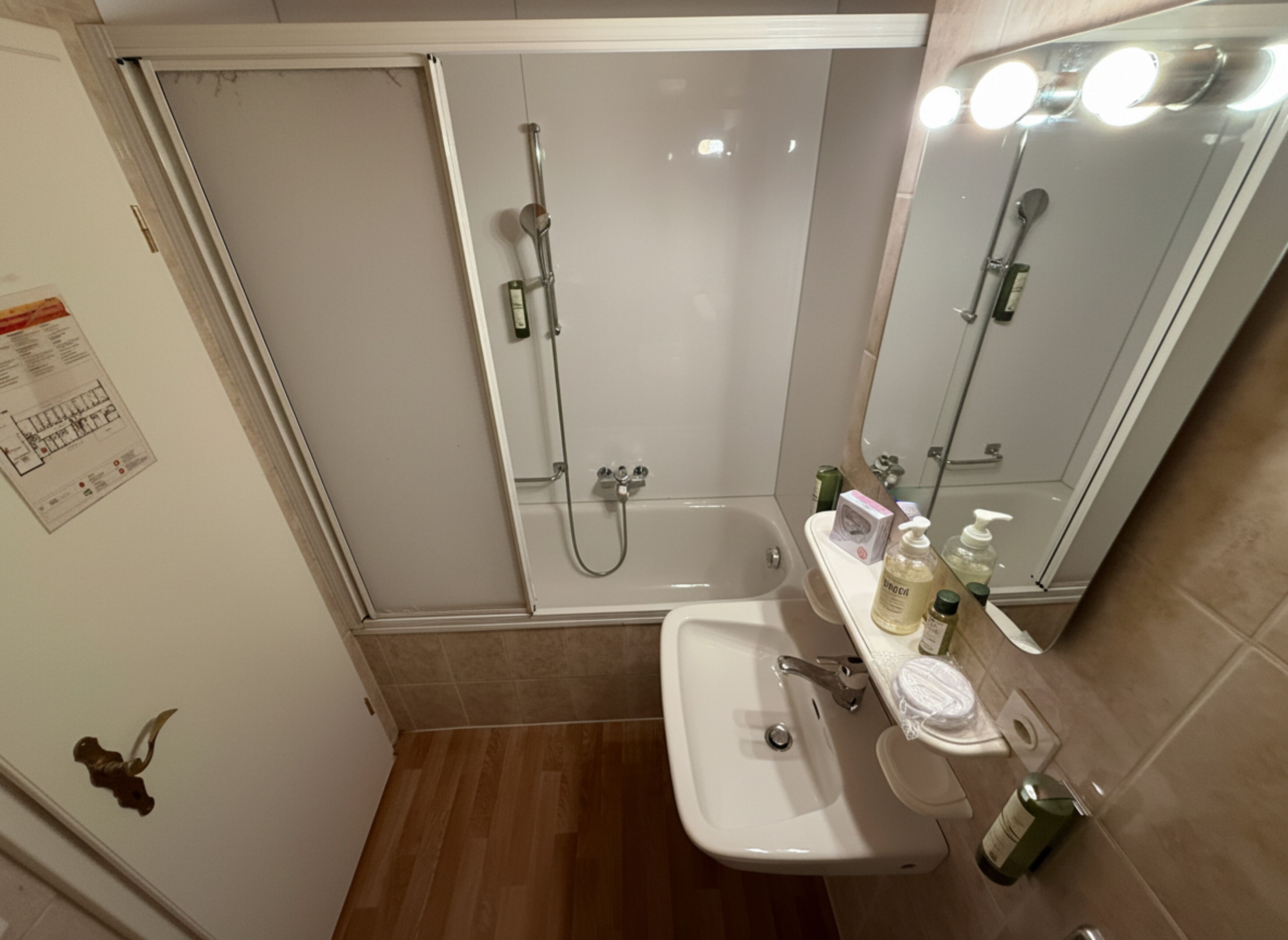 Un baño con ducha, lavamanos y espejo.