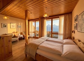 Un interior de madera con una cama grande, un sofá y una mesa.