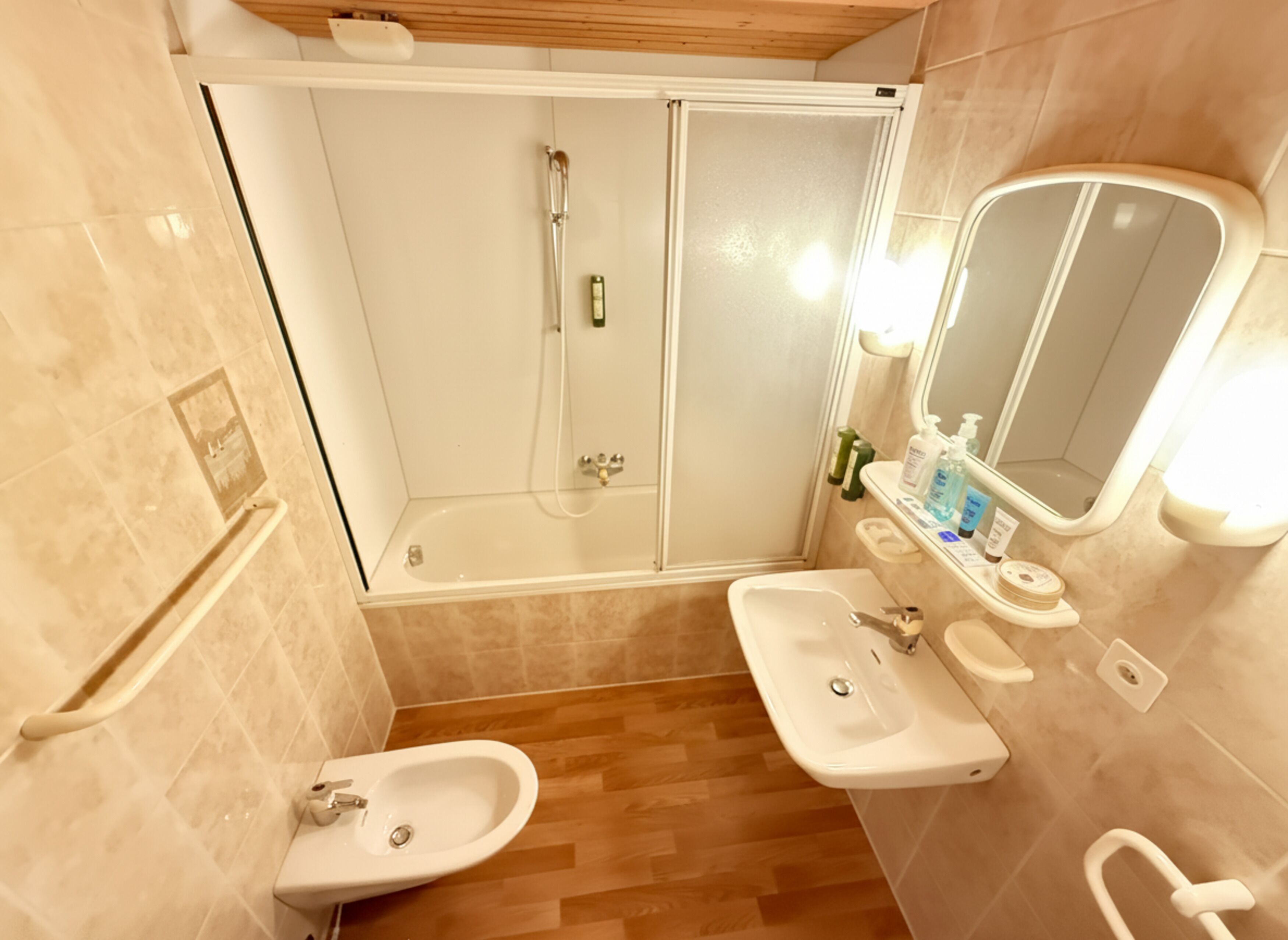 Une salle de bain avec une douche, deux lavabos, un miroir et des toilettes.