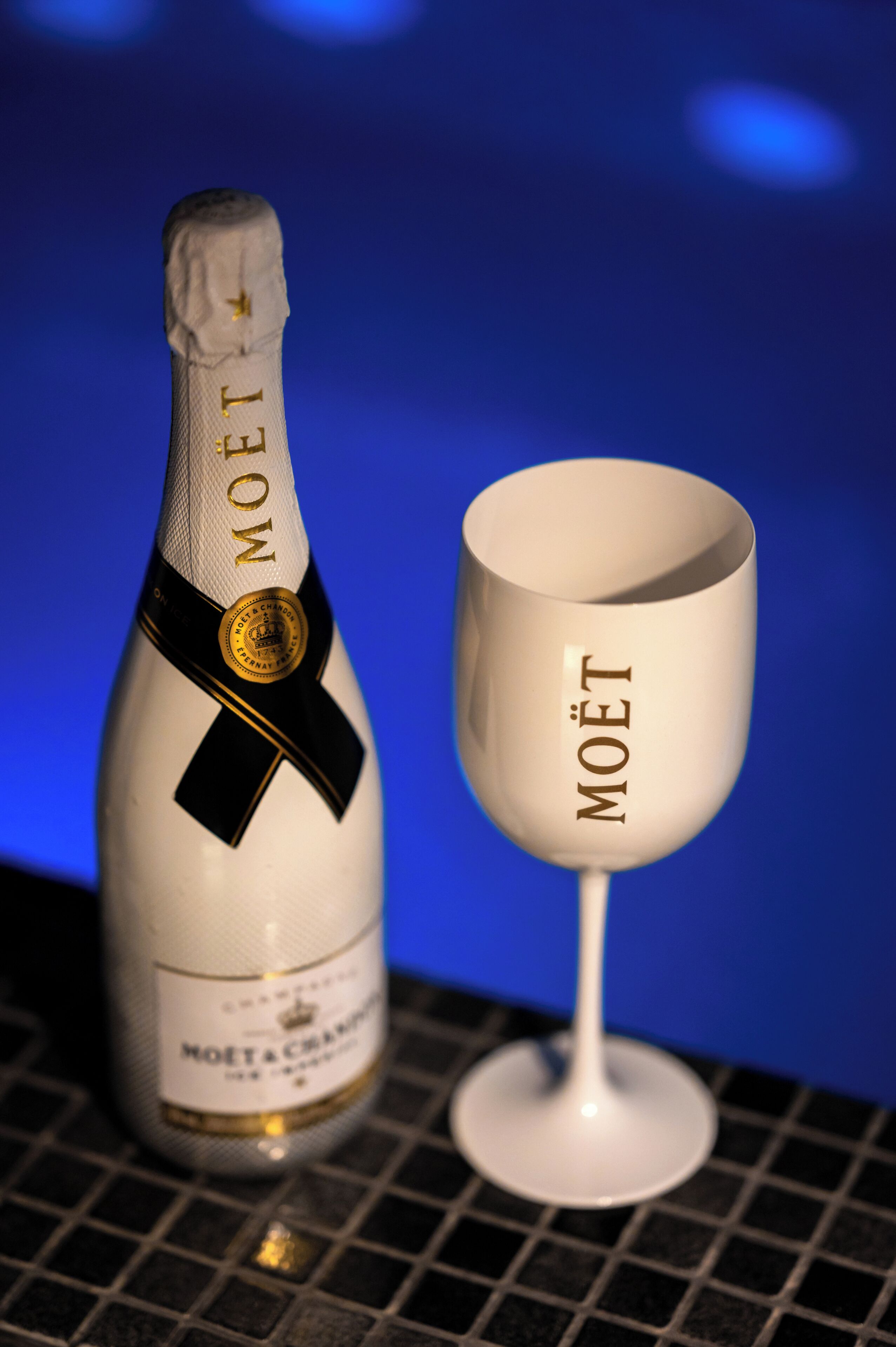 Uma garrafa de champanhe Moët e um copo com o logotipo Moët.