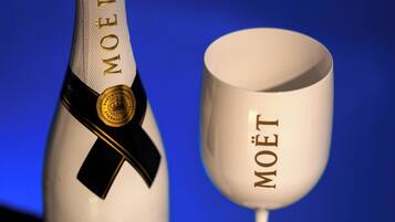 Una botella de champán Moët y una copa con el logotipo de Moët.