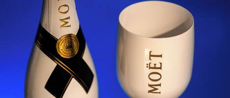 Uma garrafa de champanhe Moët e um copo com o logotipo Moët.