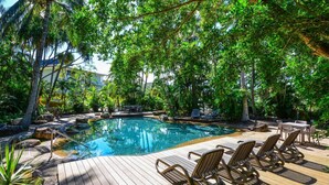 Ein Pool mit Liegestühlen und einer Holzterrasse.