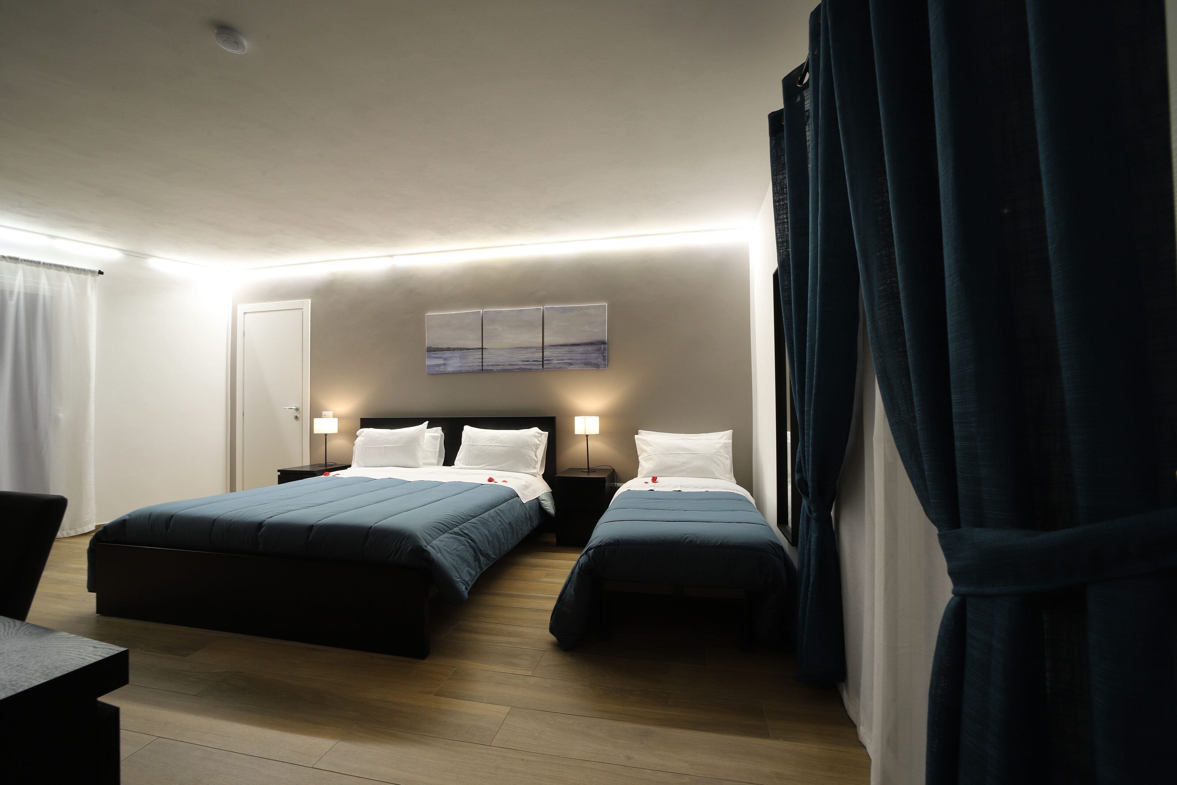 Habitación de hotel con dos camas, un escritorio y una mesita de noche.