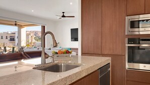 Eine moderne Küche mit Granit-Arbeitsplatten, Edelstahlgeräten und Holzschränken.
