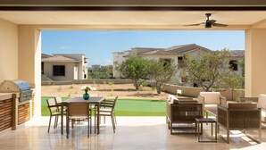 Un patio amplio con zona de comedor, mobiliario exterior y una parrilla.