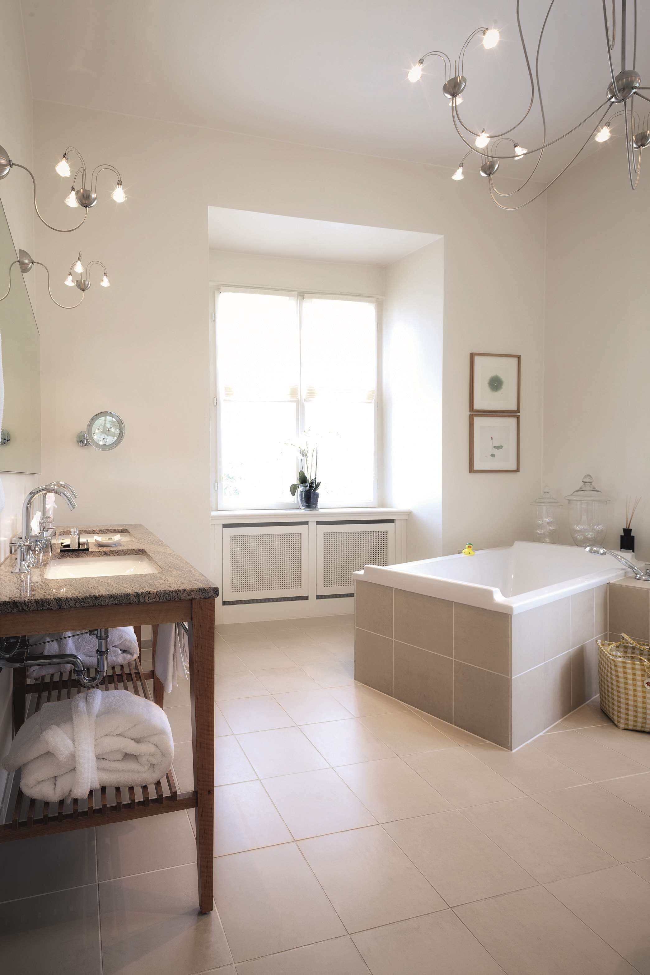 Une salle de bain moderne avec un lavabo, un miroir et une baignoire.