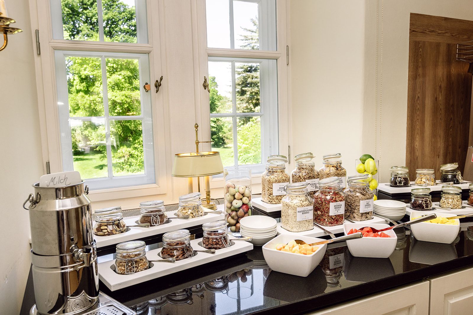 Een buffetopstelling met diverse etenswaren en een melkdispenser.