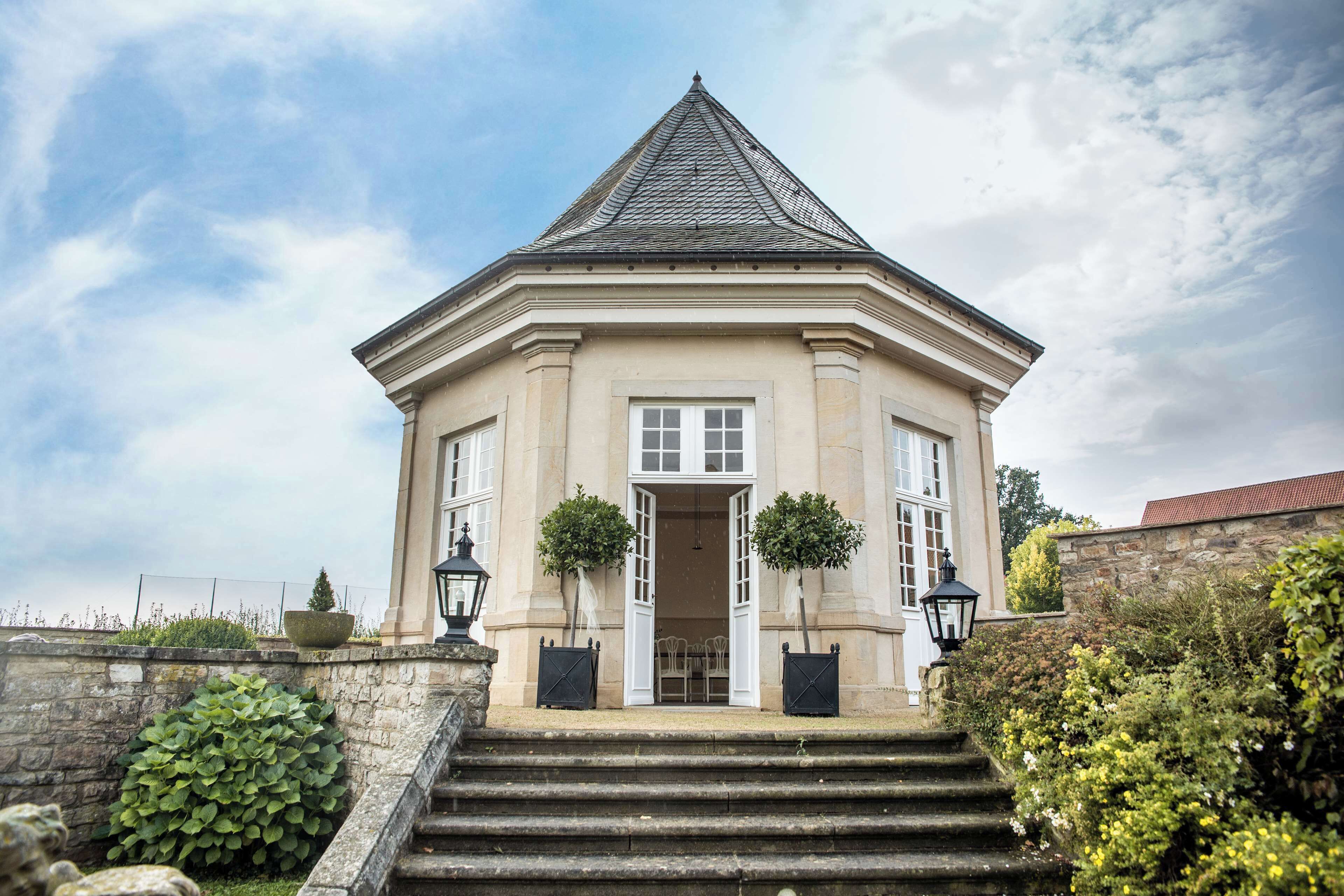 A stately building with a symmetrical facade, a central entrance, and a steeply pitched roof.